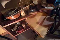 Overview of shelf with wooden music box, tray, carved animals, and wooden stand.