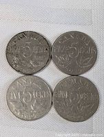 Four Canadian nickel five cent coins from the 1920s showing reverse details with denomination and maple leaf design. Coins have circulation wear and natural tarnish.