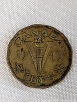 Reverse of 1943 Canada Victory Nickel showing torch, maple leaves, and date.