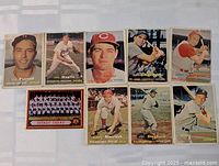 Nine 1957 Topps baseball cards laid out on a white surface showing players Jim Piersall, Sal Maglie, Hersh Fowler, Hobie Landrith, Smoky Burgess, Detroit Tigers team card, Marv Blaylock, Joe Ginsberg, Gene Stephens.