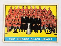 Front side of the 1961-62 Topps Chicago Black Hawks team hockey card showing the full team photo with the Stanley Cup trophy and bright yellow background.