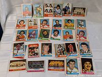 Single layered display of 33 visible hockey cards from the 1974-75 OPC series laid out flat showing a variety of players and teams, with colorful player portraits and team photos