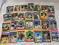 Spread of 28 individual 1975 O-Pee-Chee baseball cards laid out on a white surface, showing various players and teams including Twins, Red Sox, Phillies, Tigers, Royals, and others.