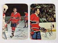 Two vintage hockey cards featuring Guy Lafleur and Larry Robinson in their Montreal Canadiens uniforms on ice, each showing a full body pose and facsimile signature.