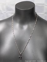 Front view of the sterling silver necklace displayed on a black bust, showing the full length and pendant details.