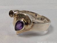 Front and side view of sterling silver ring with pear-shaped amethyst and missing setting part.