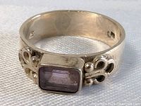 Front and angled view of the vintage sterling silver ring with rectangular amethyst gemstone and ornate silver detailing on band.