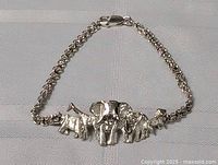 Full view of sterling silver bracelet with multiple jungle animal charms including a central elephant and other animals on linked chain with lobster clasp.