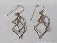 Pair of sterling silver modernist open geometric dangle earrings with hook backs shown on neutral background.