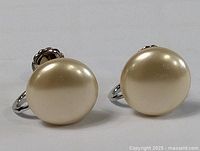 Close-up view of the front of large oval mother of pearl earrings.