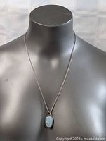 Full view of 22-inch sterling silver chain with blue stone pendant displayed on mannequin.