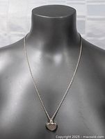 Photo showing the full necklace with heart-shaped pendant on a mannequin bust to display length and design.
