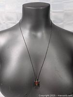 Necklace displayed on mannequin bust showing chain length and pendant placement.