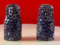 Front view of the pair of blue and white floral salt and pepper shakers, showing height and pattern detail.