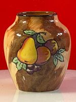Front view showing the hand-painted fruit pattern featuring a pear, apples, grapes, and leaves.