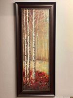 Full vertical art wall showing birch trees with red foliage in front, set in a dark wood frame with ornamental bead border.