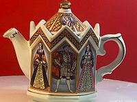 Front and side view of Sadler ceramic teapot showing painted portraits of Henry VIII and Anne Boleyn with detailed decorative patterns.