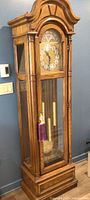 Full view of oak grandfather clock in room setting