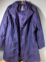 Front view of navy blue L.L. Bean outerwear coat showing the zipper, snap buttons, side pockets, and hood.