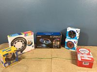 Full lot of new toys including inflatable tube, collectible figure, LED stunt car, gyro spinners, and dominoes box on display.