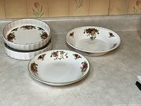 Four Royal Albert Old Country Roses dishes on countertop: 2 flan dishes stacked, large deep oval serving dish, pasta salad serving dish