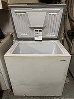 White Danby chest freezer with lid open showing interior and Energy Guide label.