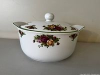 Covered casserole dish with floral pattern and green trim, lid on
