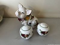Full front and side view of piggy bank and salt and pepper shakers showing Old Country Roses floral design and condition.