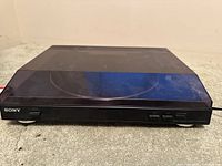 Sony PS-LX300USB turntable with closed dust cover showing front panel and buttons.