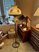 Full view of lamp showing milk glass shade, metal stand and base in room environment