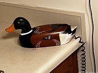 Side view of wooden mallard-shaped phone on countertop