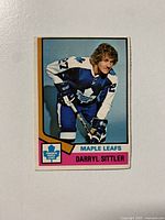 Front photo of 1974-75 OPC Darryl Sittler Toronto Maple Leafs hockey card showing full color image of the player and team branding.