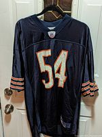 Front view of navy blue Brian Urlacher Chicago Bears jersey with number 54 and Chicago Bears stripes on sleeves.