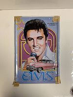 Tin sign showing colorful 1950s-style Elvis Presley portrait with microphone and classic car, still packaged with tape on corners.