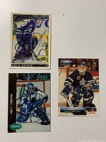 Three Felix Potvin hockey cards arranged flat showing full front view with signatures visible on two cards.