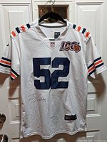 Front of the white NFL Chicago Bears jersey with number 52 and autograph in black ink on front lower left.