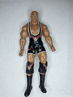 Front view of Kurt Angle action figure showing muscular build and black wrestling singlet with star designs.