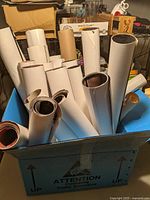 Box of rolled posters including UFC and MMA posters packed tightly together.