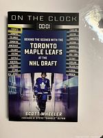 Front cover of 'On The Clock' book showing a hockey player in Toronto Maple Leafs uniform and text about the NHL Draft.