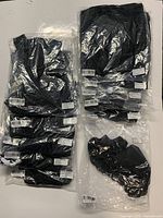 11 pairs of unopened black athletic soccer shorts in plastic packaging.