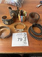 Overview of seven assorted bracelet cuffs on wooden table