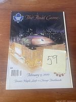 Front cover of Maple Leaf Gardens final game booklet showing illustrated night view of the arena with city skyline and logos.