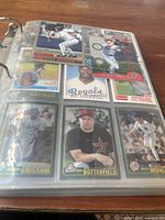 Photo showing nine baseball cards in plastic sleeves featuring players such as Greg Maddux, Bo Jackson, and Norman Garciaparra.
