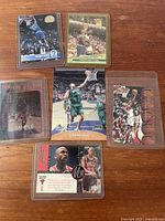 Six visible NBA basketball cards including Shaquille O'Neal, Isiah Rider sample, Grant Hill, Michael Jordan foil and roster card