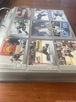 View of hockey cards in a clear page sleeve showing various NHL players in different poses from 90s to early 2000s.
