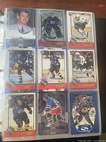 Close-up photo of binder page with NHL Upper Deck hockey cards showing players like Mike Richter, Stephane Yelle, and Steve Yzerman.