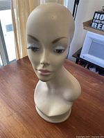 Front and side view of off-white vintage female mannequin head showing facial features and condition.