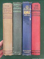 Spine view of four hardcover books with titles and authors visible.