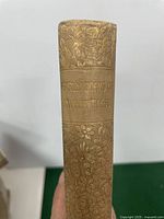 Spine of the book showing the title 'Early Poems of Whittier' with floral embossing.