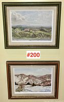 Both framed paintings hung on wall: summer view above, winter scene below